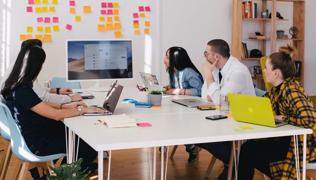 Young professionals sitting around a table viewing a graphic on a monitor