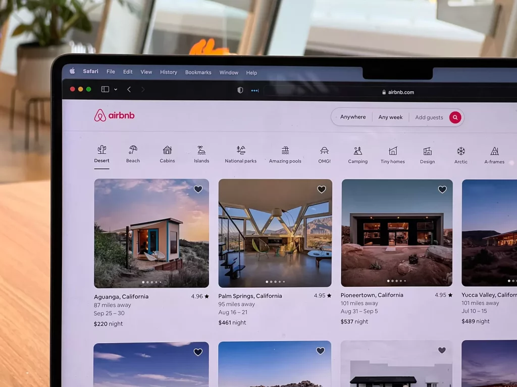 AirBnb listings visible on a laptop screen